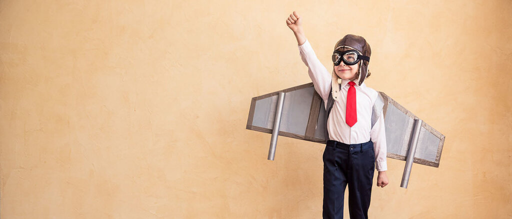 Kind als Pilot mit Flugzeugflügeln