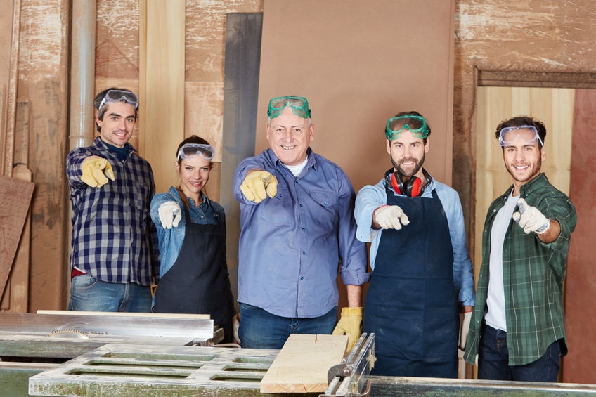 Fünf Handwerker mit Zeigefinger auf Betrachter