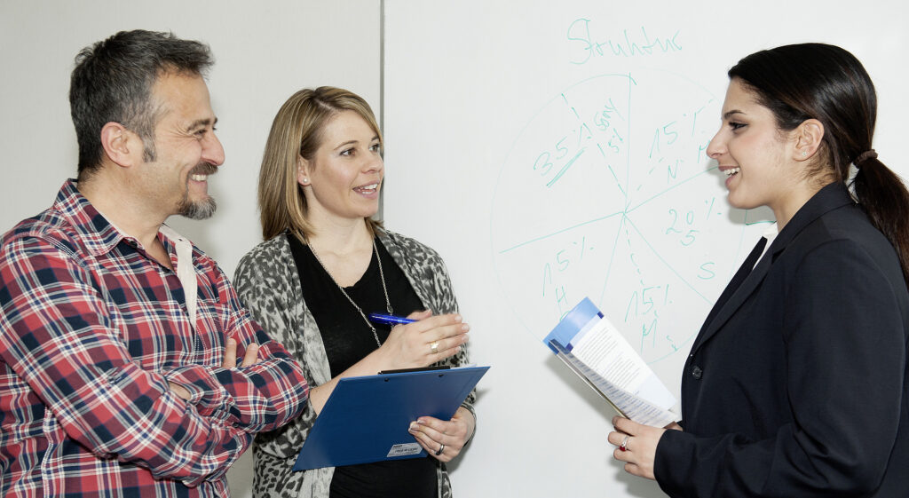 Zwei Frauen und ein Mann besprechen sich